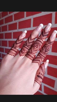 a woman's hand with henna tattoos on it