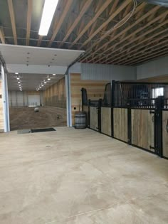 the inside of a horse barn with wooden stalls