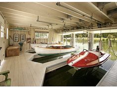 there are two boats parked in the garage next to each other and one is red