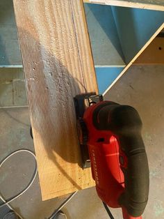 a cordless driller is hooked up to a piece of wood on the floor