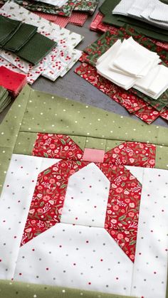 quilts laid out on top of each other with red and green fabrics, including white napkins