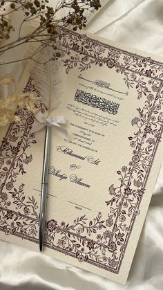 a wedding card with a pen on top of it