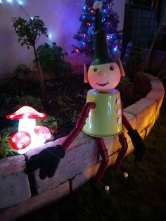 a garden decoration with a gnome in the middle and a fairy light up mushroom behind it