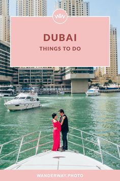 a man and woman standing on the back of a boat in front of tall buildings