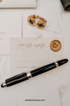 a pen and some other items sitting on top of a white table next to a piece of paper