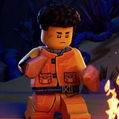 a lego star wars character is standing in front of a fire with his hands on his hips