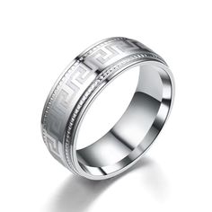 a wedding ring with greek writing on the side and an engraved design in white gold