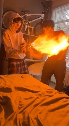 two people in a room with fire coming out of their hands