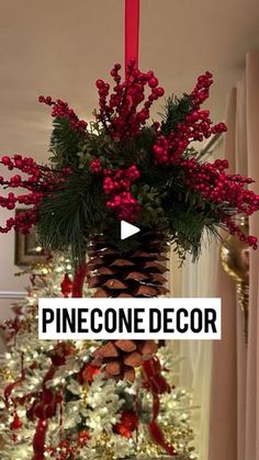 a pinecone decorated christmas tree with red ribbon