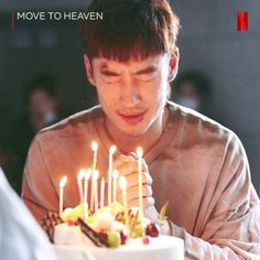 a young man blowing out candles on a cake