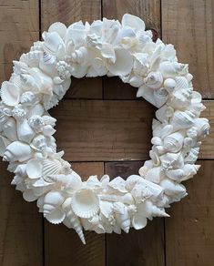 a wreath made out of seashells on a wooden wall