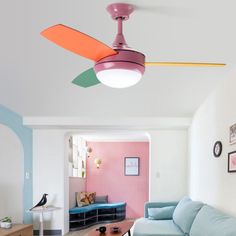 a living room with a blue couch and a pink ceiling fan