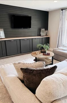 a living room filled with furniture and a flat screen tv mounted to the side of a wall