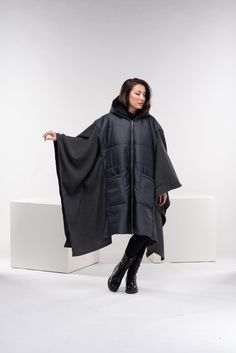 "Stay warm while staying fashionable with this unique puffer jacket poncho with oversized pockets and zipper closure, and a large cozy hood. This maxi quilted coat has a street vibe and is unisex for all body types. You can wear it in different ways, go all the way as a poncho, or halfway through. Made from two fabrics - puffer quilted fabric and wool knitted fabric, and while the textiles are different, there is a relationship in the shapes. A good jacket or coat can really make an outfit. It's the finishing touch before walking out the door. ◼️FIT This puffer jacket is a one-size design. It is roomy and oversized and it fits all our sizes from XS to 4XL. ◼The model in the picture is wearing the color Dark Gray. ◼️FABRIC ◾polyester quilted fabric with viscose lining, knitted acrylic wool Oversized Hooded Puffer Jacket With Detachable Hood, Oversized Hooded Cape For Cold Weather, Winter Outdoor Cape, Oversized Hooded Outerwear For Outdoor, Oversized Parka With Adjustable Hood For Cold Weather, Oversized Parka With Double-lined Hood For Cold Weather, Oversized Hooded Outerwear For Cold Weather, Oversized Hooded Cape For Outdoor, Oversized Hooded Outdoor Cape