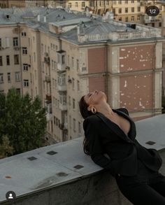 a woman laying down on top of a building