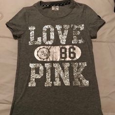 Original 1st Year Edition Of Victoria Secret Pink Clothing Line - Grey And Sparkling Silver Short Sleeve ‘Love 86 Pink’ In Brand New Condition Shirt Was Preserved Over The Years And Kept In A Vacuum Sealed Bag Due To Being One Of The First Early Editions Of The Vs Pink Clothing Line Silver Short Sleeve Graphic Tee, Trendy Silver Crew Neck Tops, Silver Casual T-shirt With Letter Print, Silver Crew Neck T-shirt With Letter Print, Casual Silver T-shirt With Letter Print, Silver Graphic Tee With Crew Neck, Trendy Silver Short Sleeve Top, Silver Graphic Tee With Short Sleeves, Silver Casual T-shirt With Graphic Print