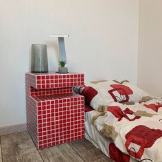 two red and white beds in a room with wood flooring next to each other