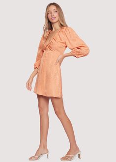 Whether you're home by curfew or keep the party going all night, The Beach Peach Mini Dress is your summer staple! The elegance of this style comes from the cinched trim along the V-neck detail with an adjustable tie and keyhole bust. This silhouette features quarter length sleeves with elastic trim and and am empire waist secured by a back zipper. Keep it dressy with favorite heel or add sneakers for a more casual vibe. WDWC13864 Imported 70% Polyester, 30% Viscose Model is 5 ft 9 inches; Bust: Beach Mini Dress, Peach Orange, Night Out Dress, Summer Staples, Beach Dresses, Short Rompers, Empire Waist, Different Styles, Night Out