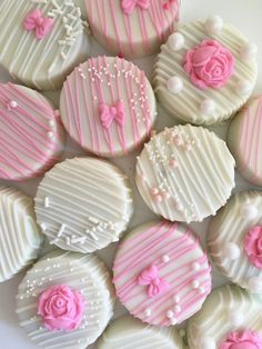 some pink and white decorated cookies on a plate with the words set of 12 chocolate covered oreos all covered in white frosting