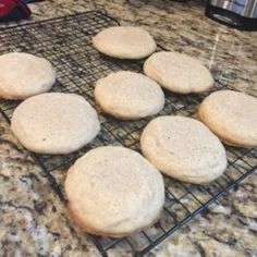 eight uncooked biscuits cooling on a rack next to an instant pressure cooker