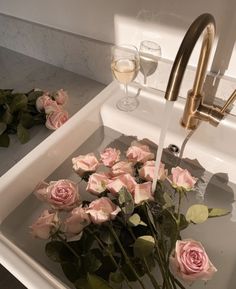 pink roses are being washed in a sink