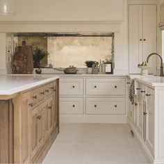 a large kitchen with white cabinets and marble counter tops