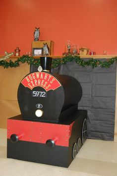 a black and red train engine sitting on top of a white floor next to a fireplace