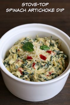 a white bowl filled with spinach artichoke dip