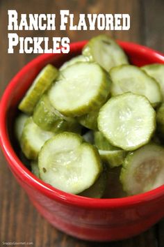 a red bowl filled with sliced cucumbers on top of a wooden table and text overlay reads ranch flavored pickles