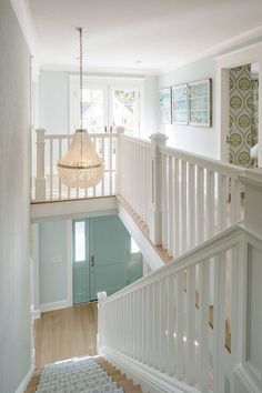 an open staircase leading up to the second floor with white railing and handrails