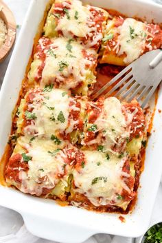 lasagna casserole in a white dish with a fork on the side