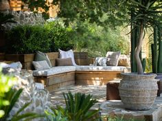 an outdoor seating area surrounded by plants and trees