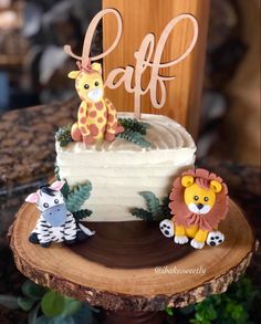 a cake decorated with animals and the word cafe on top is sitting on a tree stump