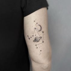 an arm with a tattoo on it that has saturn in the sky and stars around it