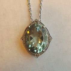 "I want to be able to wear this gorgeous minty green amethyst as a necklace. I love how it has unique textures around the amethyst." ~8ct Oval Green Amethyst Made in Palladium Four cognac diamonds at the four sides in palladium. The edges have milligrained texture. Contact us to create unique jewelry like this.