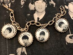 This vintage Beatles charm bracelet let is from 1964. It is a NEMS bracelet, so it is an authentic Beatles item licensed by their original management. The brace is a solid gold tone metal alloy, the face feel to be enameled. It measures 7 inches in length. As with all antiques, please understand this has been previously loved and some wear may be present. So please review pictures carefully and ask questions if there's something you would like to know more about. Please make sure you love it and Vintage Gold-tone Jewelry With Logo Charm, Vintage Personalized Gold Charm Bracelet, Personalized Vintage Gold Bracelets, Personalized Vintage Gold Charm Bracelet, Vintage Gold Personalized Bracelets, Vintage Gold Charm Bracelet Collectible, Vintage Gold Jewelry Souvenir, Vintage Brass Charm Bracelets, Vintage Collection Gold Bracelets With Charms