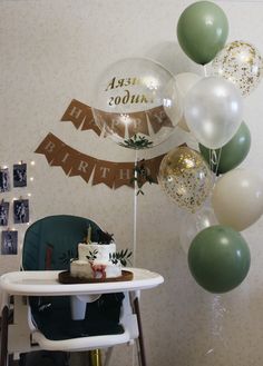 a baby's first birthday party with balloons and cake