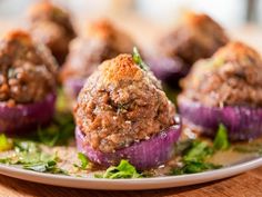 some meatballs are sitting on a plate with lettuce and garnish