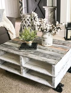 a coffee table made out of pallet wood with a plant on top and some books