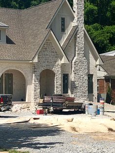 a large brick house under construction next to trees