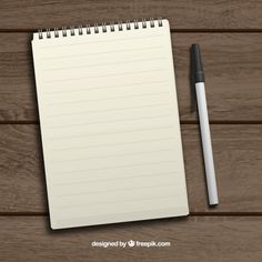 a notepad with a pen next to it on a wooden surface