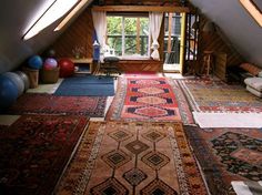 a room with many rugs and windows in it