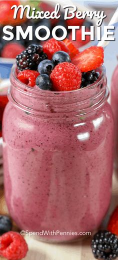 mixed berry smoothie in a mason jar with strawberries and raspberries on the side