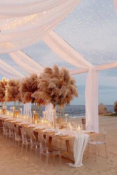 a long table set up with white linens and pamolite centerpieces