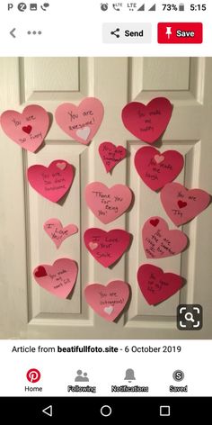 a bunch of pink hearts hanging on a door with words written on them in spanish