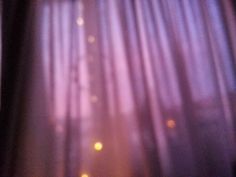 blurry image of curtains with lights in the background