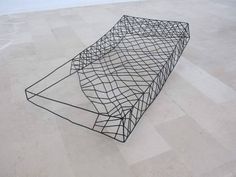 a black sculpture sitting on top of a white floor