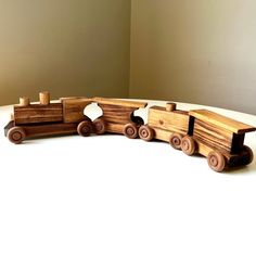 a wooden toy train is sitting on the floor next to a white wall and beige walls