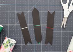 three pieces of black paper cut out to look like they are being used as scissors