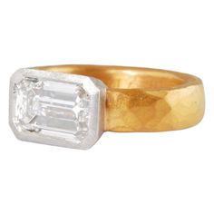 an 18k gold and diamond ring, with a square cut diamond in the center